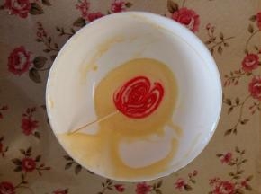 11.取一小勺蛋糕糊，用牙签沾适量粉色色素，把面糊搅拌均匀，装在裱花袋里，