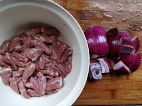 将所有处理好的鸡心，用流动的清水冲洗，把凝结成块状的淤血冲洗干净。清洗净淤血是去除腥味的第三步。同时将紫皮洋葱切大块。