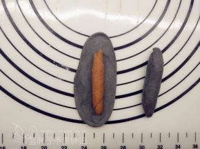 竹炭小剂子一样擀成椭圆形，中间放上可可面团，将它包起来。