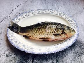 把鱼的两面都切斜刀，在鱼的两面抹少许盐，腌制10分钟。