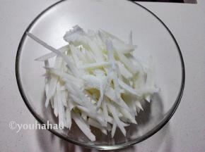 萝卜丝放入大碗中，撒上适量的盐、白糖拌匀，腌渍1~2个小时