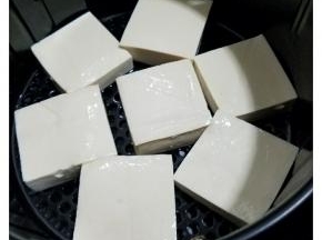 2、把蒜米压成蓉，香葱红辣椒洗净后切成粒，放在碗里滴几滴花生油拌匀。