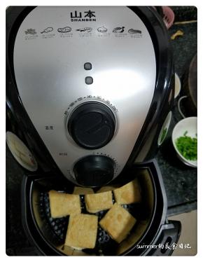 3、把空气炸锅用200度预热3分钟，拉出炸篮，铺上豆腐块刷上少许油。