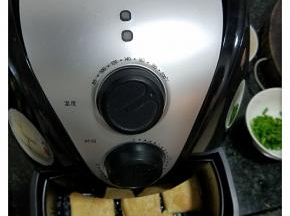 3、把空气炸锅用200度预热3分钟，拉出炸篮，铺上豆腐块刷上少许油。