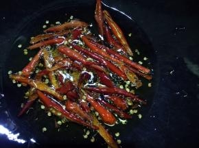 玉米油烧至五成热熄火，放入干红辣椒爆香炸出红油