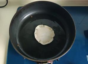 平底锅放少许油低温煎制饺子饼，建议做一个煎一个，不然蛋液会将饺子皮泡软渗漏，你会泪崩的