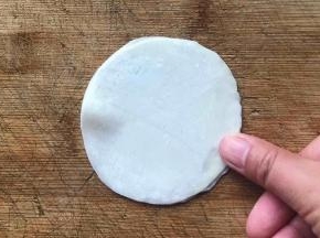 盖上另一张饺子皮，用手指轻轻按压或捏紧边缘处，一定要捏紧