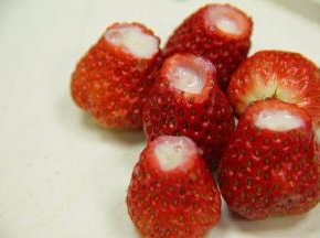 挖好的草莓，往内挤入炼奶。