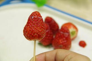 把切出来的草莓尖端封上，轻轻的用牙签插上（小心插穿内里哦）