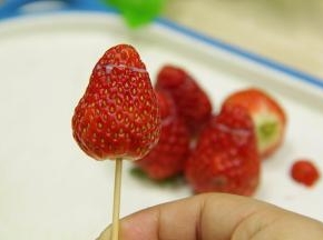 把切出来的草莓尖端封上，轻轻的用牙签插上（小心插穿内里哦）