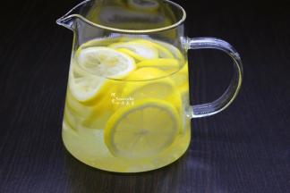 切好柠檬片倒入玻璃壶、加上冰水；