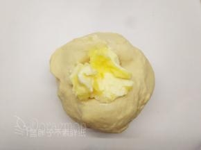 除黄油和黑芝麻外，将面团中的其它原材料按照底层液体，中层粉类，上层糖、盐和酵母的顺序放入面包桶中，启动一个揉面程序，揉至能拉出厚膜后加入黄油，继续一个揉面程序，揉至扩展阶段。
