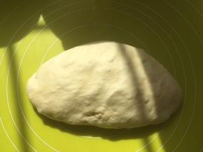 将面团取出，在揉面垫上按压排气