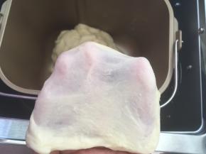 加入牛奶，开始揉面程序和成面团，面团揉好后，切下一小块看一下面团的状态，有扩展性，可以撑出膜即可