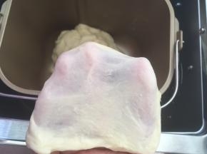 加入牛奶，开始揉面程序和成面团，面团揉好后，切下一小块看一下面团的状态，有扩展性，可以撑出膜即可