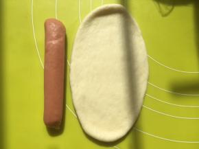 取一份松弛好的面团，用擀面杖擀成长条，长度比香肠长一点即可