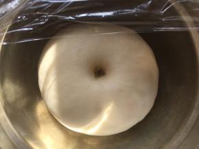 之后盖保鲜膜室温发酵至两倍大，发酵好的面团手指按下去有个圆圆的洞，有轻微回弹即可