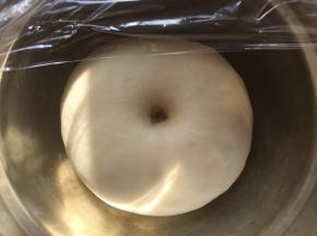 之后盖保鲜膜室温发酵至两倍大，发酵好的面团手指按下去有个圆圆的洞，有轻微回弹即可