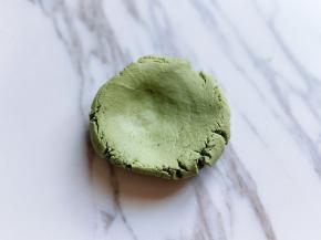 取一小块面团，用手心压扁。