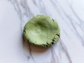 取一小块面团，用手心压扁。