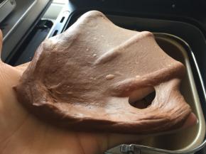 揉好的面团取一小团进行轻撑拉出容易破洞但洞口周边光滑厚薄膜，即可加入室温软化的黄油