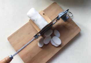 用工具把年糕切成薄片，没有工具就直接用刀切，注意安全