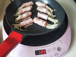 不粘锅中，刷上少许食用油，将培根金针菇卷摆放好，炒菜模式煎至2分钟即可。