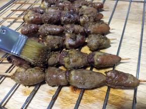 鸡心串烤10分钟后取出来，逐个将鸡心串刷上调好的孜然汁。