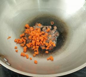 锅里重新放少许油下腊肠，煸至腊肠里的肥肉变透明。加入胡萝卜，翻炒片刻。