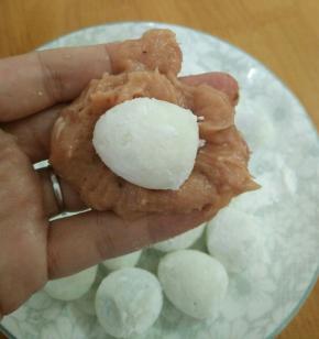 取适量肉泥，放入一个鹌鹑蛋，像包包子一样包好。