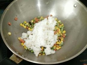接着放入米饭，把米饭炒散。