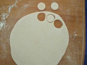 用少许面粉加适量水揉成白色面团。擀成片，压出小圆形。