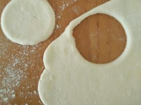 白色面团充分排气后，擀成片，用饺子模具压出圆形。