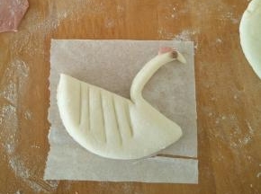 剪出小圆形，沾上去做眼睛。红色面团也擀成片，剪出鹅冠。