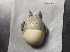 两只耳朵一共1克，揉成两头尖的圆柱形状，用刮刀切成两半，沾点牛奶，做出耳朵的样子，两只手臂一共2克，揉成圆形再切成两半，也沾点牛奶，做出手臂的样子