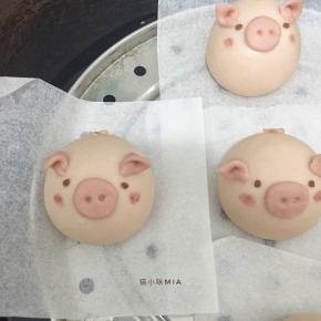 小猪面团的身体表面刷一点点牛奶，帮助粘贴，将小猪的眼睛、耳朵、鼻子、尾巴粘在对应的位置，用刷子粘点水和红曲粉，刷出腮红