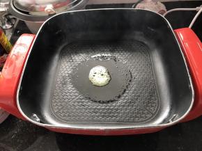 锅中加2勺油，打入一只鸭蛋，用铲子将鸡蛋搅散，并放入一半的大蒜炒香，加入烤肠和青菜叶翻炒一会。