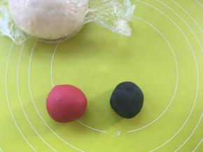 取2小块白色面团，分别加入竹碳粉跟甜菜根粉揉成红色跟黑色，之后盖保鲜膜松弛，没有甜菜根粉用红曲粉也可以