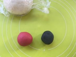 取2小块白色面团，分别加入竹碳粉跟甜菜根粉揉成红色跟黑色，之后盖保鲜膜松弛，没有甜菜根粉用红曲粉也可以
