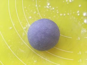 包裹上香芋馅后，用手掌沾干粉搓圆，稍稍压扁一点点