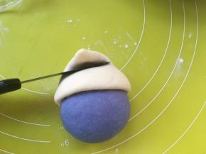 之后用刀背压下一帽子中间部分，让帽子顶部向前对折，就像蓝精灵的帽子一样