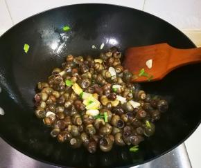 放入螺丝翻炒至水汽至干