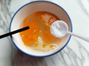 将鸡蛋敲碗里，加入盐，用筷子打散。