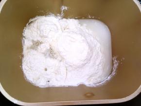 将面粉加水，用面包机和成面团，手揉面团要将面团揉至表面光滑状态