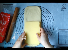 黄油提前擀成薄片状备用，把醒好的面团根据擀成比黄油片稍宽一点，长约1.5倍的长方片状，将黄油片摆在2/3处（如图示）