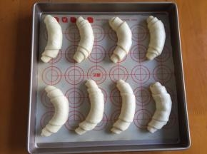 从上向下卷起，放入烤盘，放入烤箱二次发酵30分钟