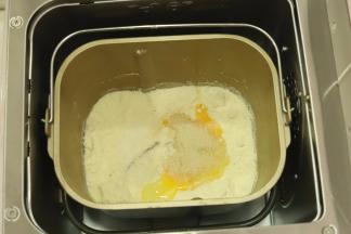 将面粉和黄油倒入面包机桶内，再放入牛奶，酵母，糖和鸡蛋