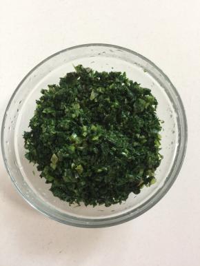 取一小份处理好的野菜切成碎末装入碗中备用。