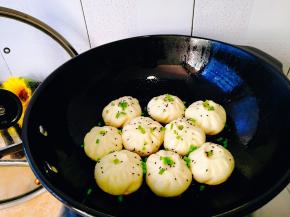 至水分收干打开锅盖撒上芝麻和葱花再煎一下即可