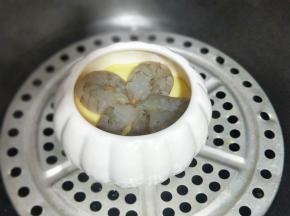 10分钟后蛋羹液已经凝固，放上腌制好的虾仁。盖上盖子继续蒸约3分钟。
